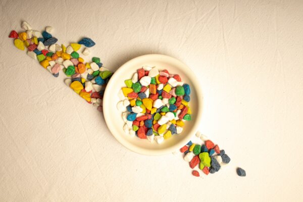 A white bowl filled with colorful candies on top of a table