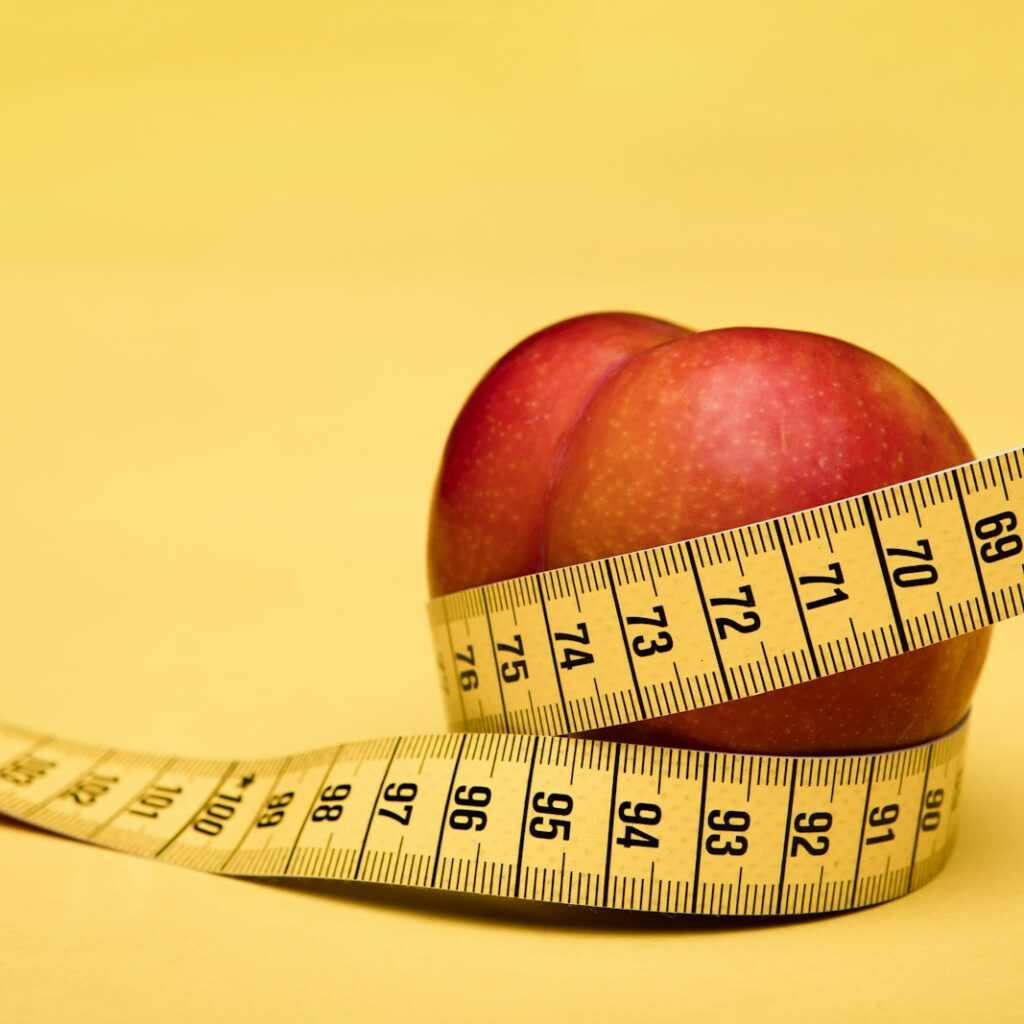 red apple fruit with tape measure