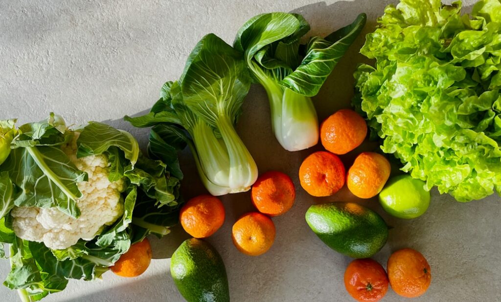 a table topped with lettuce, carrots and other vegetables