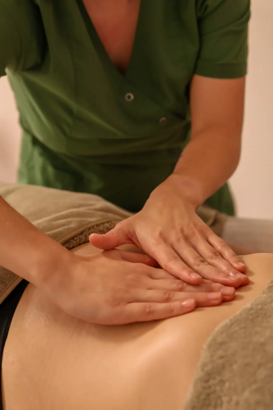 Mains d'une praticienne posées à plat pendant un massage