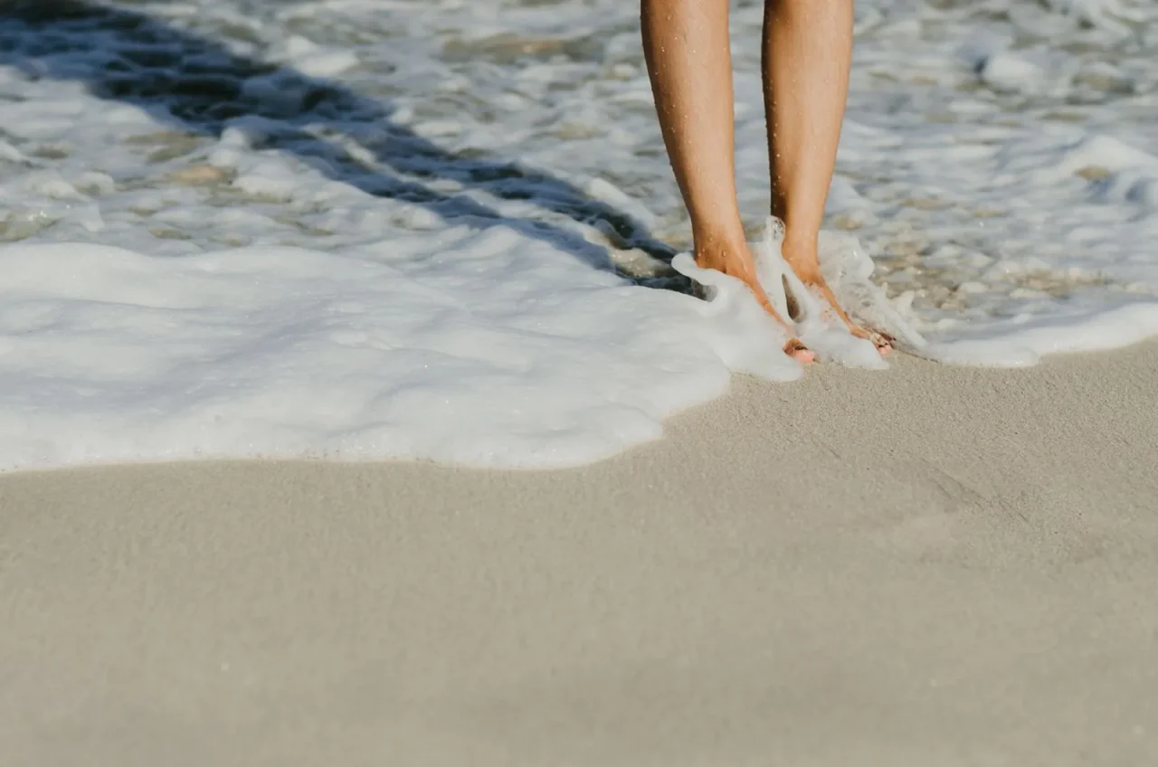 Des pieds dans l'eau, au bord des vagues