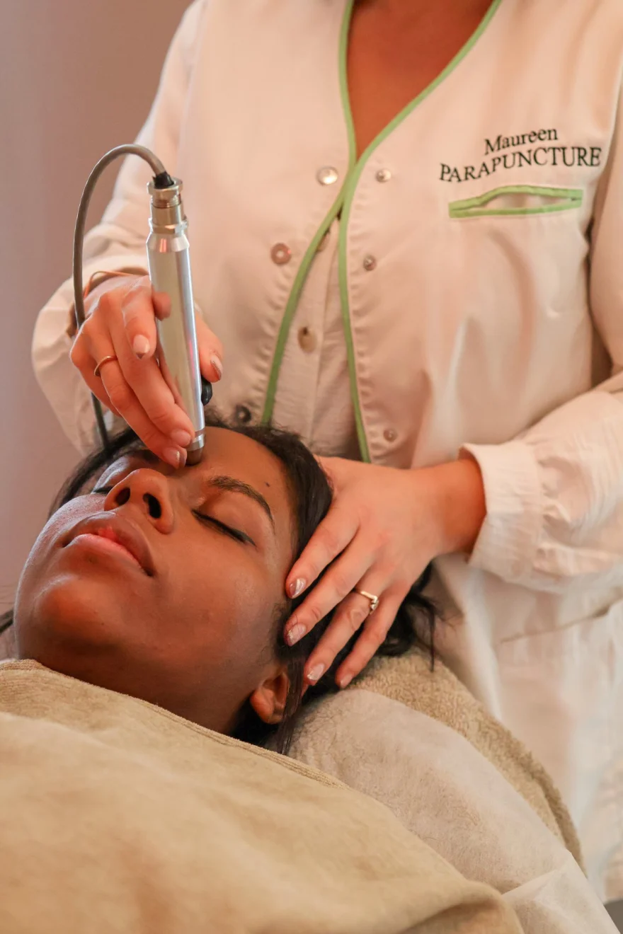 Stylet de luxopuncture posé sur le front pendant une séance