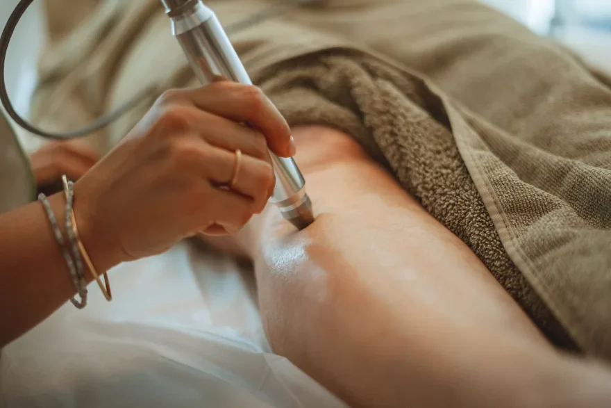 Stylet de luxopuncture posé sur la peau d’une cliente allongée, tenu par une praticienne, au cabinet de Rochefort